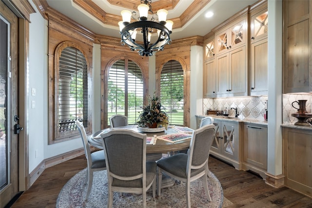 dining space with an inviting chandelier, ornamental molding, dark hardwood / wood-style floors, and a tray ceiling