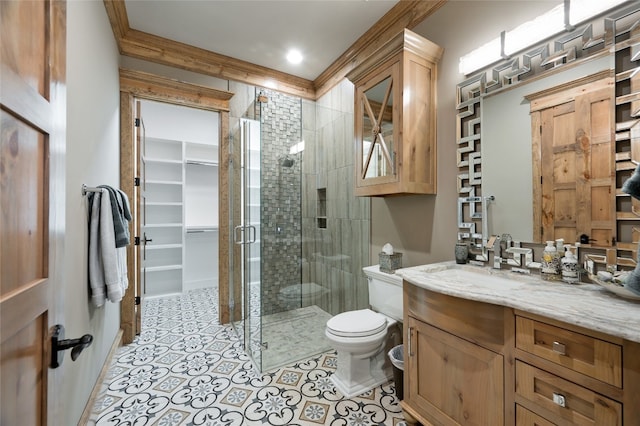 bathroom with an enclosed shower, vanity, tile floors, toilet, and crown molding