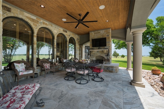 view of terrace featuring ceiling fan and an outdoor living space with a fireplace