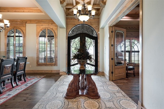 foyer with coffered ceiling, a notable chandelier, dark wood-type flooring, and beamed ceiling