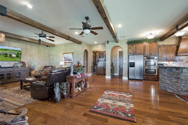 living room with ceiling fan, sink, beam ceiling, and dark hardwood / wood-style flooring