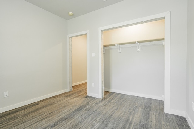 unfurnished bedroom with a closet and dark hardwood / wood-style floors