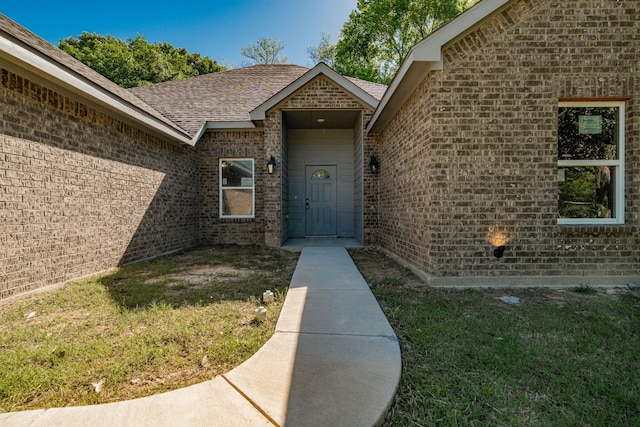 doorway to property featuring a lawn