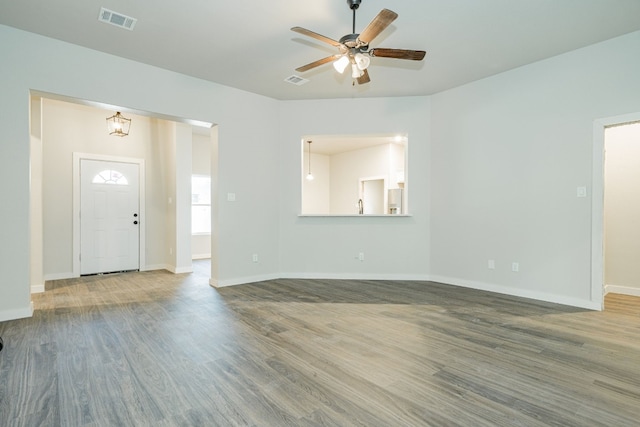 unfurnished living room with dark hardwood / wood-style flooring and ceiling fan