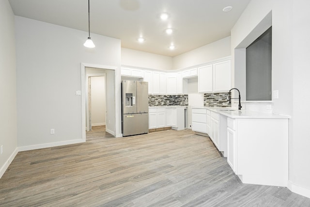 kitchen featuring light hardwood / wood-style floors, white cabinets, stainless steel refrigerator with ice dispenser, and tasteful backsplash