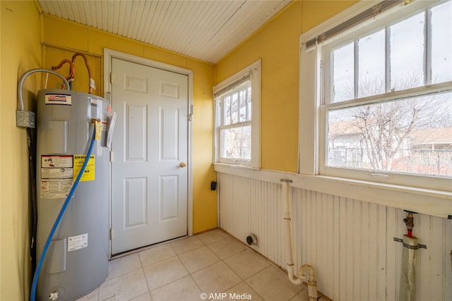 1832 Commercial Ave, Anson, TX 79501 - clothes washing area with light tile patterned floors, water heater, and electric dryer hookup