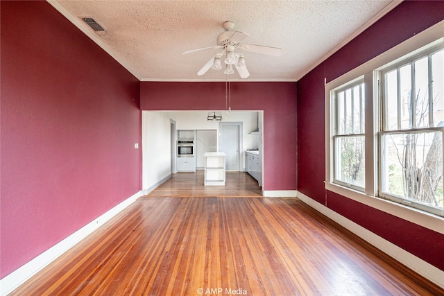 1832 Commercial Ave, Anson, TX 79501 - unfurnished living room with ornamental molding, hardwood / wood-style floors, and a textured ceiling