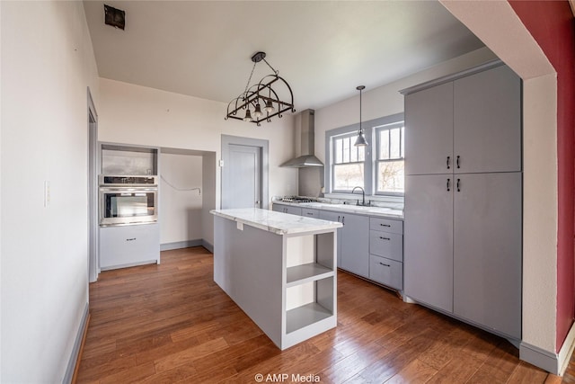 1832 Commercial Ave, Anson, TX 79501 - kitchen featuring a kitchen island, appliances with stainless steel finishes, decorative light fixtures, sink, and wall chimney exhaust hood