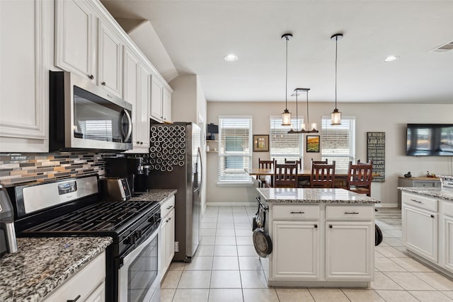 kitchen with white cabinets, stainless steel dishwasher, decorative light fixtures, a center island, and sink