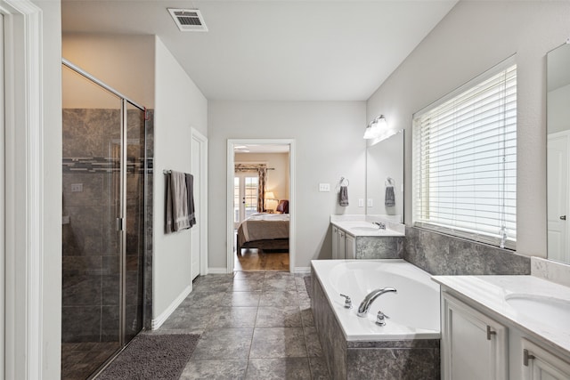 bedroom with ceiling fan, light wood-type flooring, and ensuite bath