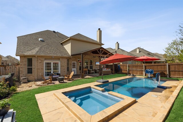 view of swimming pool with a patio, an in ground hot tub, and french doors