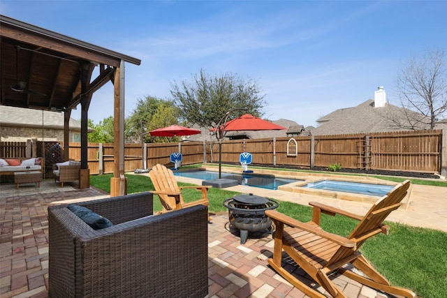 view of patio / terrace with a fire pit and a swimming pool with hot tub