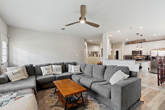 living room with ceiling fan and light hardwood / wood-style floors