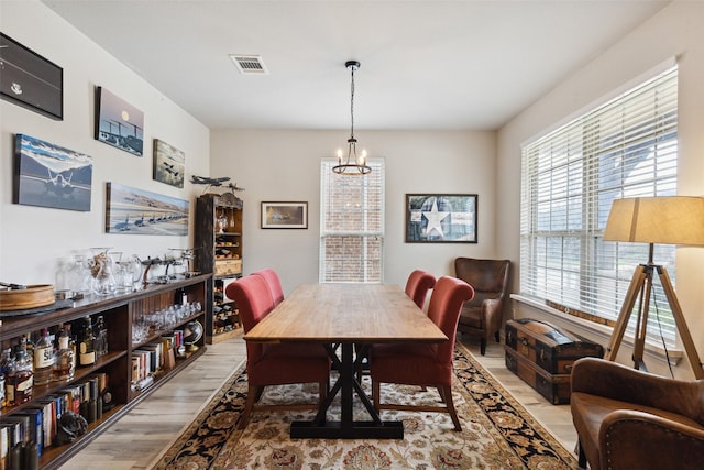 dining space featuring light hardwood / wood-style floors and a notable chandelier