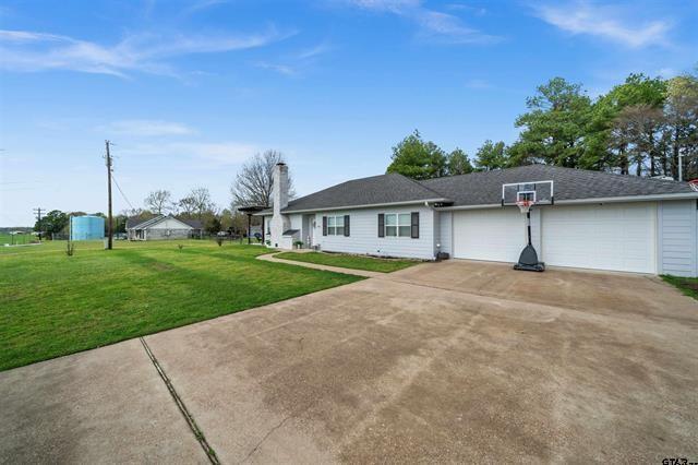 ranch-style house with a garage and a front lawn