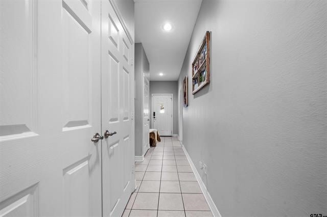 hall with light tile patterned floors