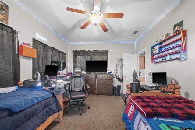 bedroom with carpet flooring, ceiling fan, and crown molding