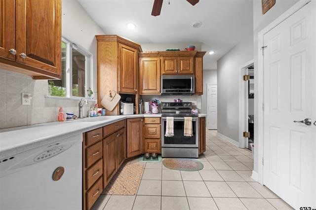 kitchen with ceiling fan, light tile patterned flooring, sink, and appliances with stainless steel finishes