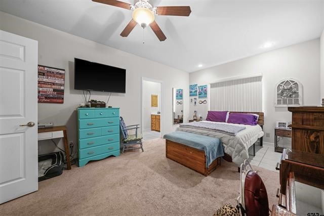 carpeted bedroom featuring ceiling fan and ensuite bath