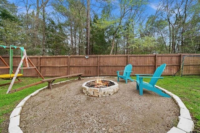 view of play area with a yard and an outdoor fire pit