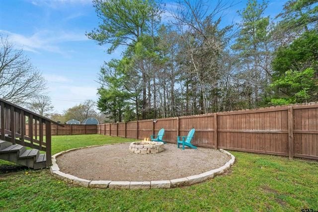 view of yard with a wooden deck and an outdoor fire pit