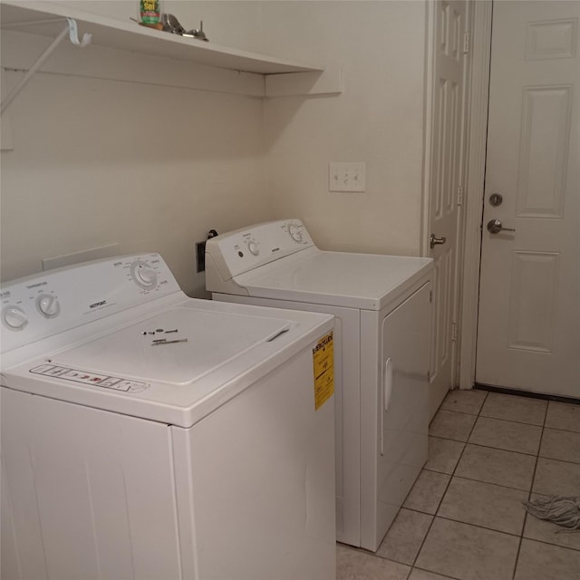 laundry area with washer and clothes dryer and light tile patterned floors