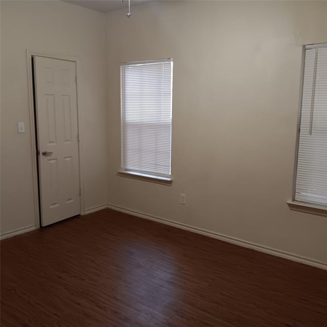 unfurnished room with dark wood-type flooring