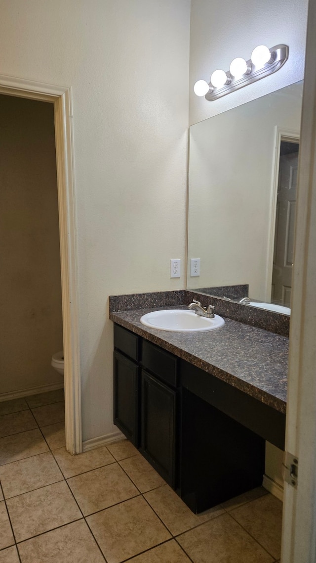 bathroom featuring tile patterned flooring, vanity, and toilet