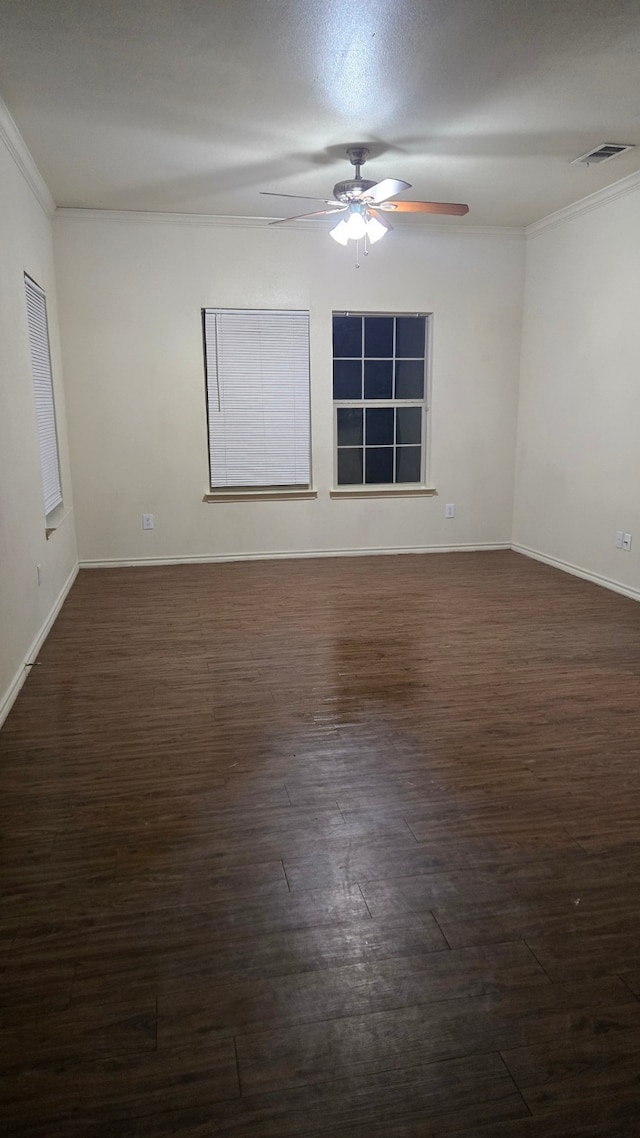 empty room with ceiling fan, dark hardwood / wood-style flooring, and crown molding