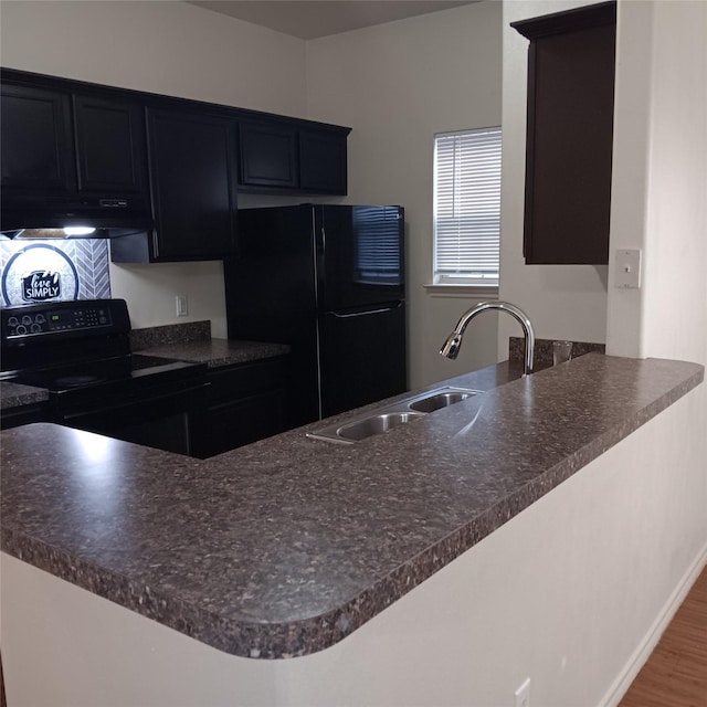 kitchen with kitchen peninsula, sink, dark wood-type flooring, and black appliances