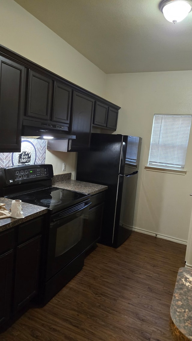 kitchen with dark stone counters, dark wood-type flooring, and black appliances