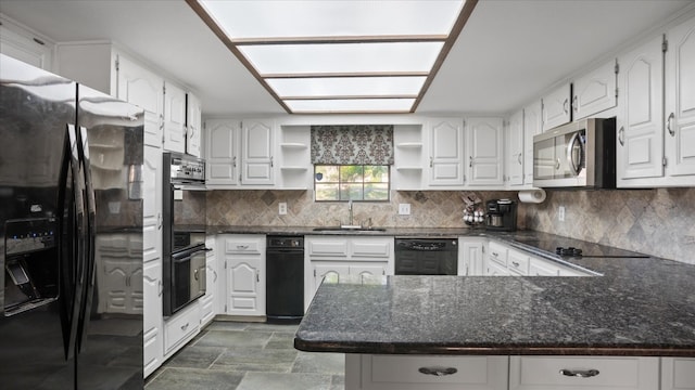 kitchen featuring white cabinets, dark stone countertops, black appliances, backsplash, and sink