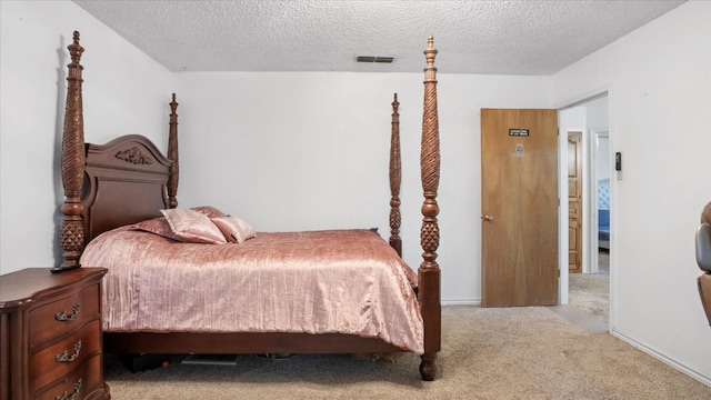 bedroom with a textured ceiling and light colored carpet