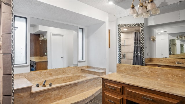 bathroom with a textured ceiling, vanity, and a bath to relax in