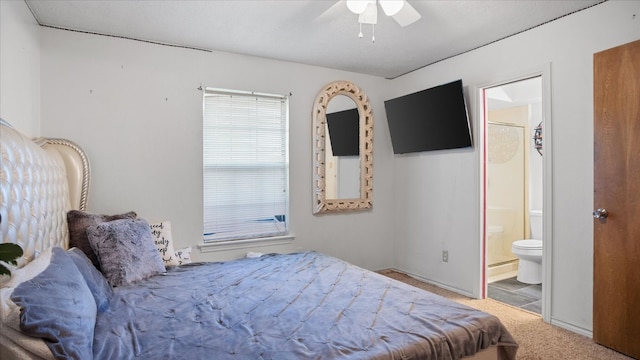 carpeted bedroom with ensuite bathroom and ceiling fan