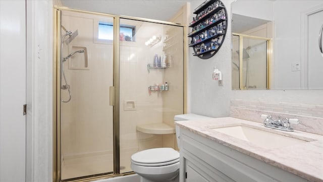 bathroom with a shower with door, large vanity, and toilet