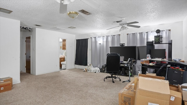 office area with ceiling fan, a textured ceiling, and light carpet