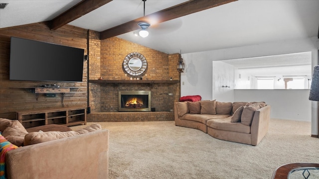 living room with ceiling fan, a brick fireplace, vaulted ceiling with beams, and carpet