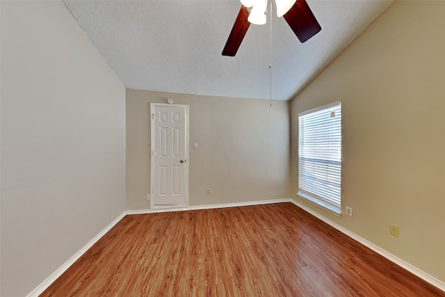 spare room featuring vaulted ceiling, a textured ceiling, hardwood / wood-style floors, and ceiling fan