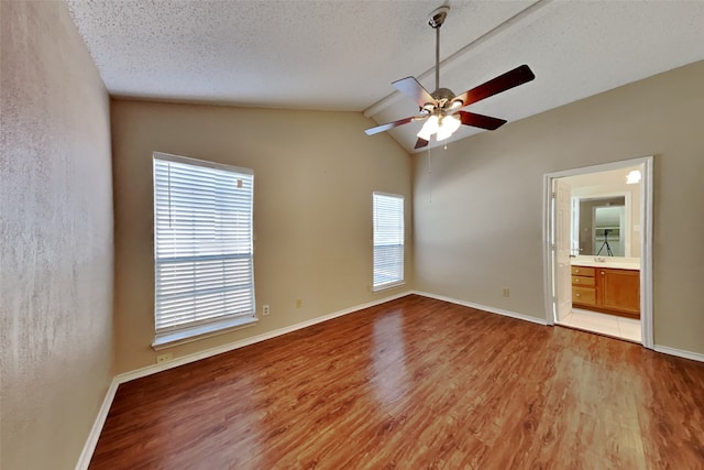 spare room featuring ceiling fan, light hardwood / wood-style floors, a textured ceiling, and vaulted ceiling