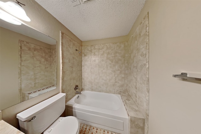 bathroom with tiled shower / bath, toilet, and a textured ceiling