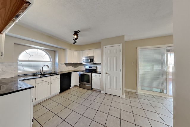 kitchen featuring light tile patterned floors, plenty of natural light, stainless steel appliances, and sink