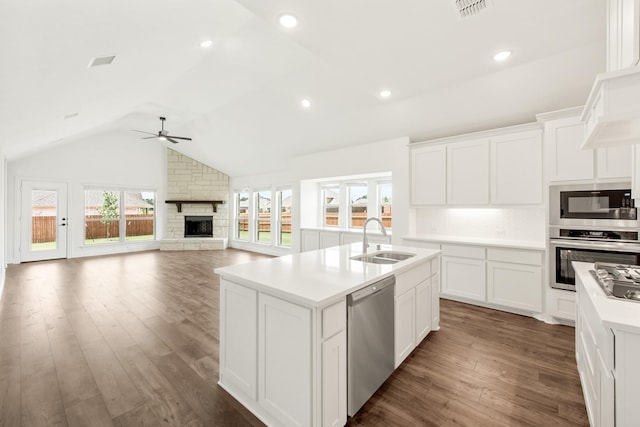 kitchen featuring white cabinetry, sink, stainless steel appliances, and an island with sink