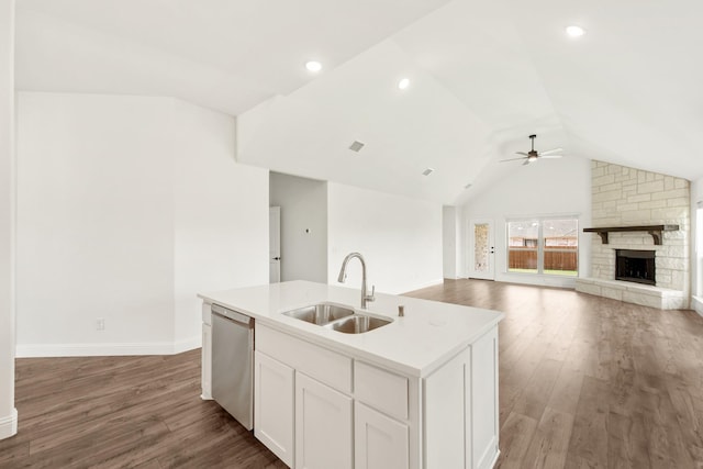 kitchen with vaulted ceiling, white cabinetry, dishwasher, sink, and a center island with sink