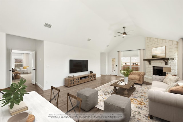 living room featuring hardwood / wood-style floors, a fireplace, high vaulted ceiling, and ceiling fan