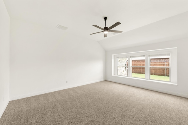 carpeted spare room featuring ceiling fan and lofted ceiling