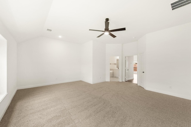 empty room featuring ceiling fan, vaulted ceiling, and light carpet