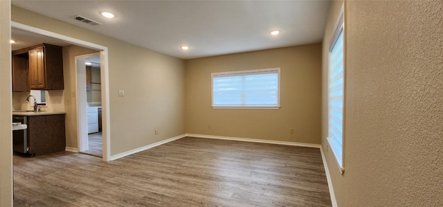 spare room featuring wood-type flooring and sink