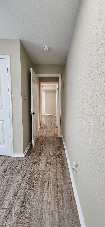 corridor with dark wood-type flooring and a textured ceiling