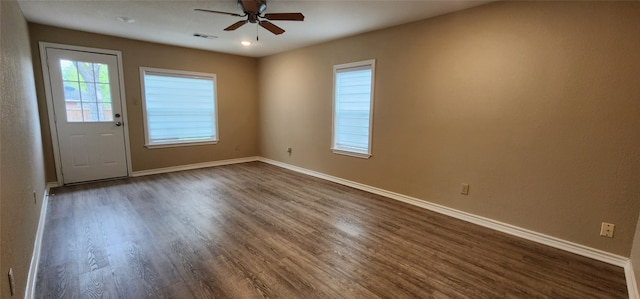 empty room with ceiling fan and dark wood-type flooring